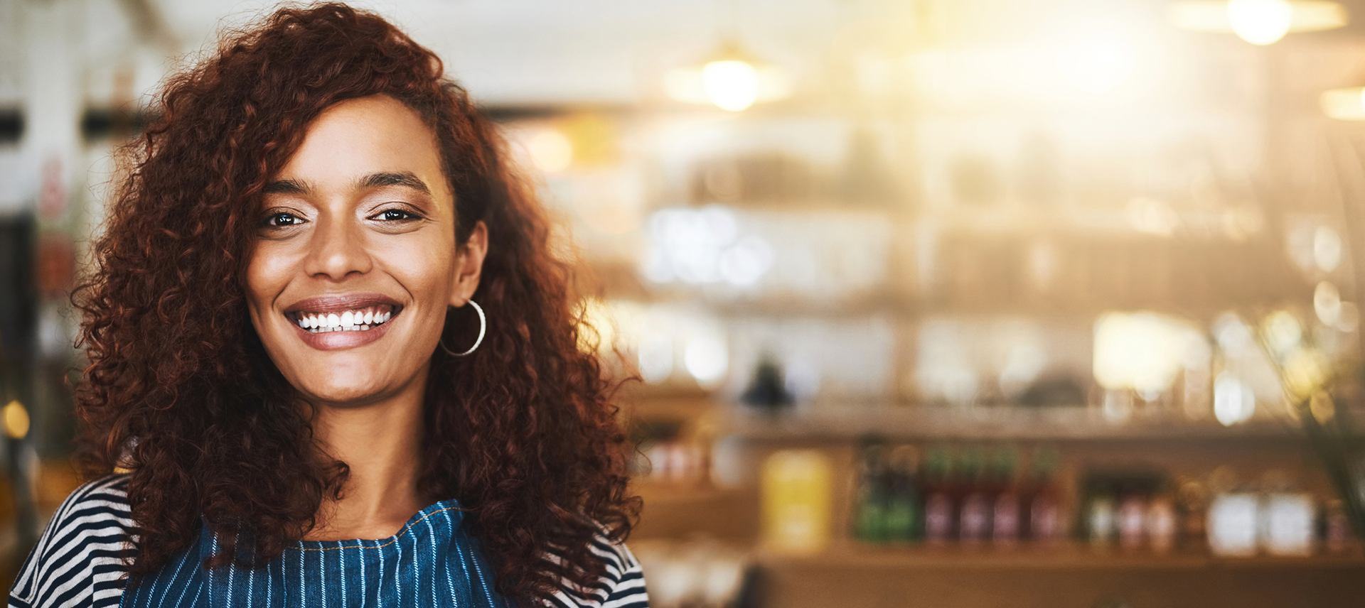 A smiling business owner in her café, ready to welcome matched travelers